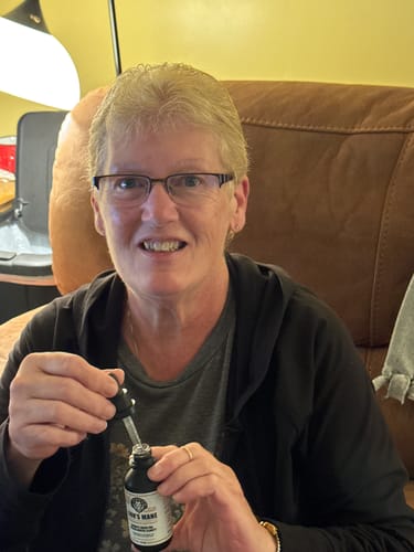 Verified customer holding Lion's Mane bottle